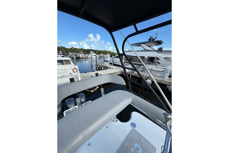 Slide: The Image of 2024 Contender 39 ST boat interior at marina, showcasing seating and docked yachts. - 33