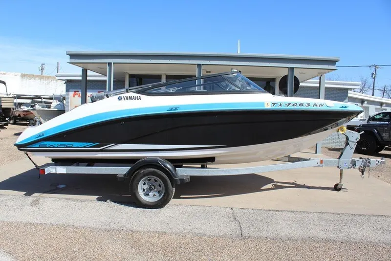 Slide: The Image of 2019 Skeeter SX190 boat on trailer, featuring Yamaha branding, parked outdoors. - 2