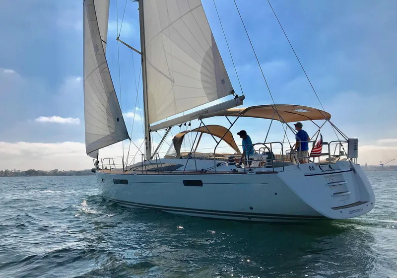 Slide: The Image of 2014 Jeanneau 57 sailboat cruising on open water under clear skies. - 2