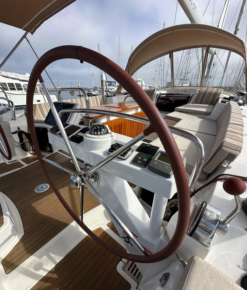 Slide: The Image of 2014 Jeanneau 57 yacht cockpit with steering wheel and navigation controls. - 36