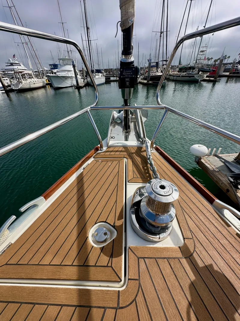 Slide: The Image of Bow of 2014 Jeanneau 57 yacht docked in marina, showcasing deck and winch. - 47