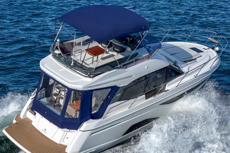 Slide: The Image of 2024 Bavaria R40 yacht cruising on open water with blue canopy. - 30