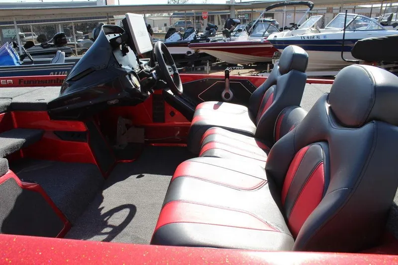 Slide: The Image of 2018 Skeeter ZX225 boat interior with black and red seating, steering console, and dashboard. - 10