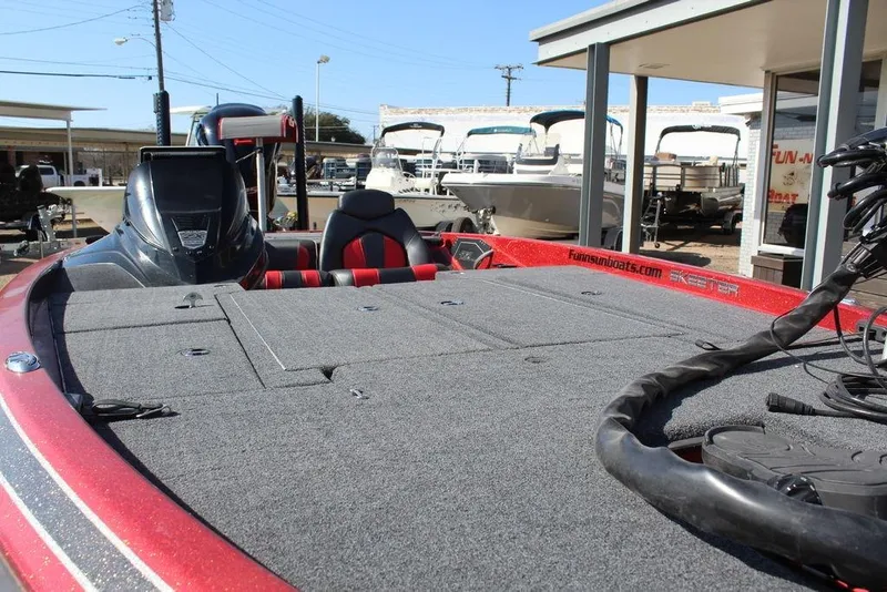 Slide: The Image of 2018 Skeeter ZX225 bass boat with spacious deck, parked at a dealership. - 8