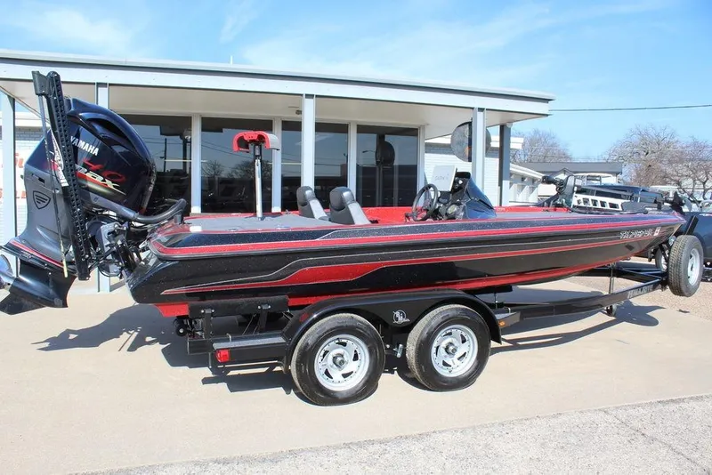 Slide: The Image of 2018 Skeeter ZX225 bass boat with Yamaha engine, parked on a trailer outside a building. - 9