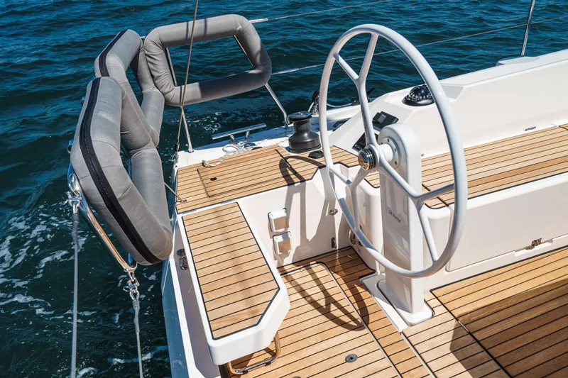 Slide: The Image of 2023 Bavaria C42 yacht cockpit with wooden deck and steering wheel on open water. - 25