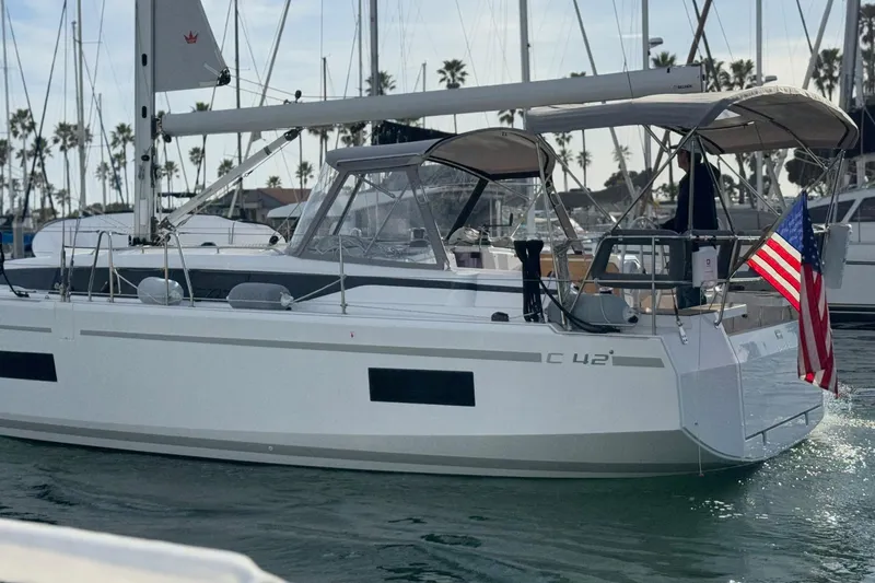 Slide: The Image of 2023 Bavaria C42 sailboat docked, featuring sleek design and American flag. - 3