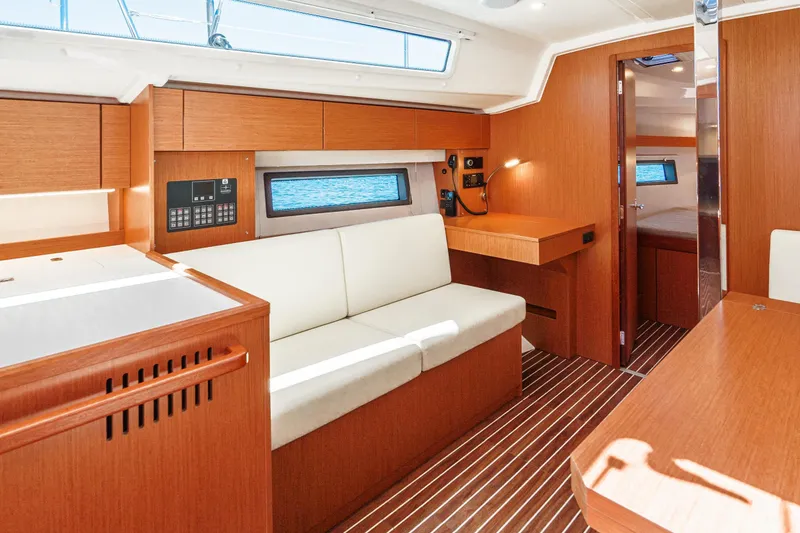 Slide: The Image of 2023 Bavaria C42 yacht interior with modern wood finish and white seating. - 36