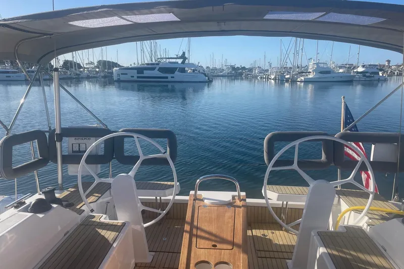 Slide: The Image of Cockpit view of 2023 Bavaria C42 yacht in a marina, surrounded by boats. - 53