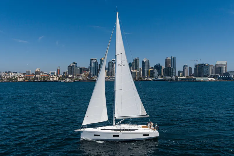 Slide: The Image of 2023 Bavaria C42 sailboat cruising near city skyline under clear blue sky. - 9