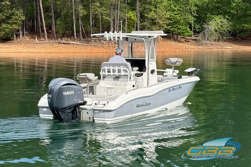 Slide: The Image of 2022 NauticStar 251 Hybrid boat on calm lake with Yamaha outboard motor. - 17