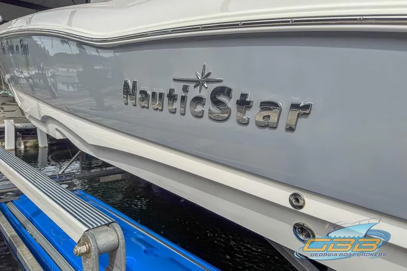 Slide: The Image of 2022 NauticStar 251 Hybrid boat on a lift, showcasing sleek design and branding. - 25