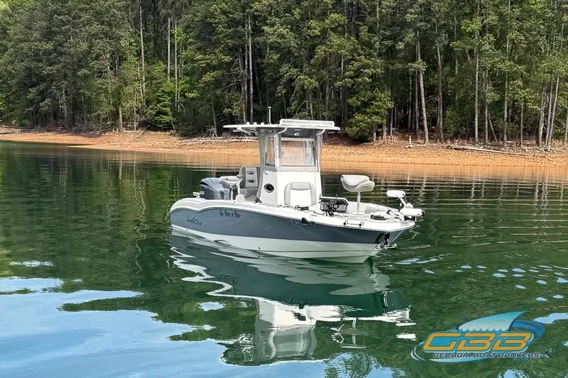 Slide: The Image of 2022 NauticStar 251 Hybrid boat on serene lake with forest backdrop. - 28