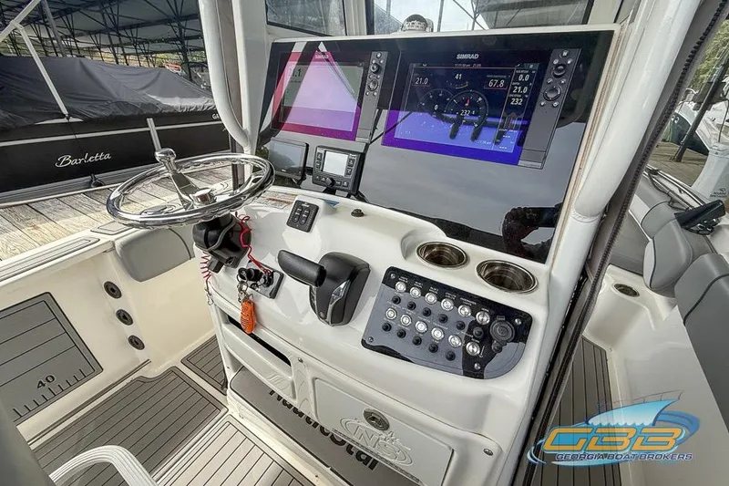 Slide: The Image of 2022 NauticStar 251 Hybrid boat dashboard with advanced controls and navigation screens. - 4