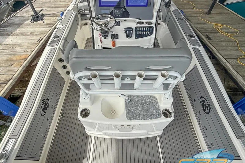 Slide: The Image of 2022 NauticStar 251 Hybrid boat interior with helm, rod holders, and sink. - 7