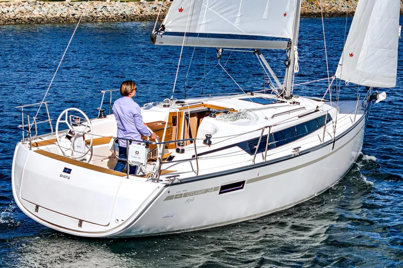 Slide: The Image of 2024 Bavaria Cruiser 34 sailing on water with person at the helm. - 5