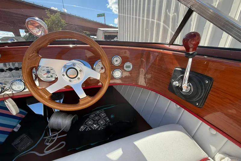 Slide: The Image of Interior of a 1992 Elite Craft Riveria boat with wooden steering wheel and dashboard controls. - 12