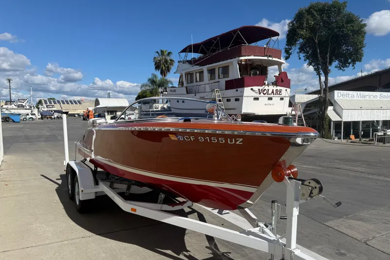 Slide: The Image of 1992 Elite Craft Riveria boat on trailer at marina, clear sky background. - 2