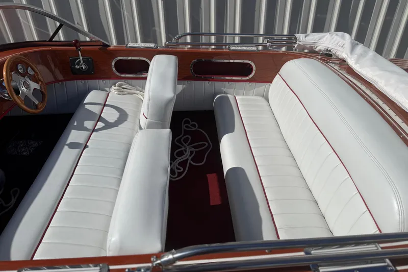 Slide: The Image of Interior of a 1992 Elite Craft Riveria boat with white leather seats and wooden accents. - 7