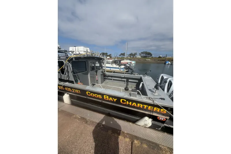 Slide: The Image of 2016 North River 29 Offshore boat docked, featuring "Coos Bay Charters" signage. - 25