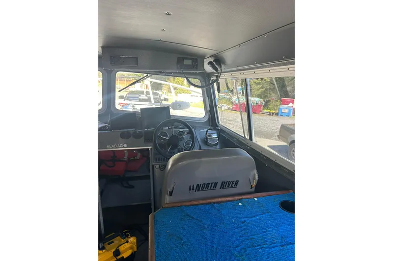 Slide: The Image of Interior of a 2016 North River 29 Offshore boat, featuring steering wheel and dashboard. - 5