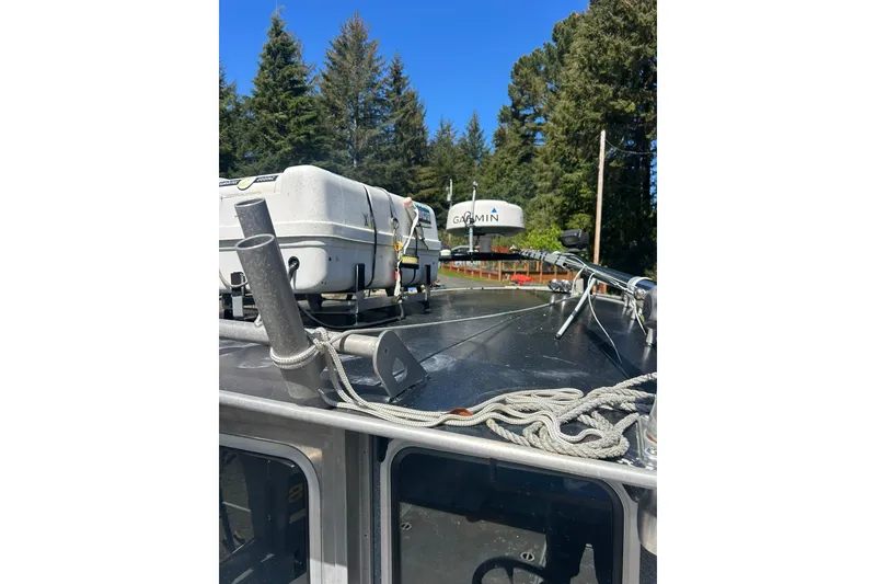 Slide: The Image of 2016 North River 29 Offshore boat roof with Garmin equipment and ropes, surrounded by trees. - 9