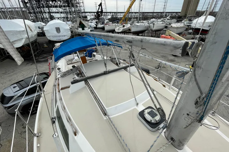 Slide: The Image of 1989 Catalina 30 sailboat on dry dock, surrounded by other boats and equipment. - 11