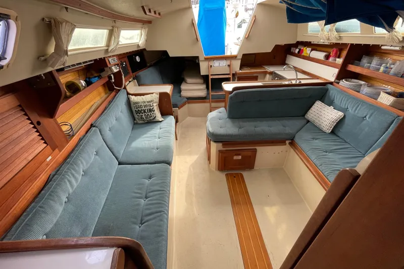 Slide: The Image of Interior of a 1989 Catalina 30 sailboat with cozy seating and wooden accents. - 18
