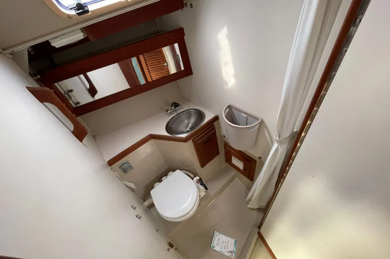 Slide: The Image of 1989 Catalina 30 boat bathroom with sink, toilet, and mirror. - 19