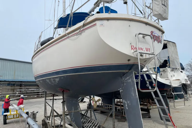 Slide: The Image of 1989 Catalina 30 sailboat on dry dock in Racine, WI, with maintenance crew nearby. - 2