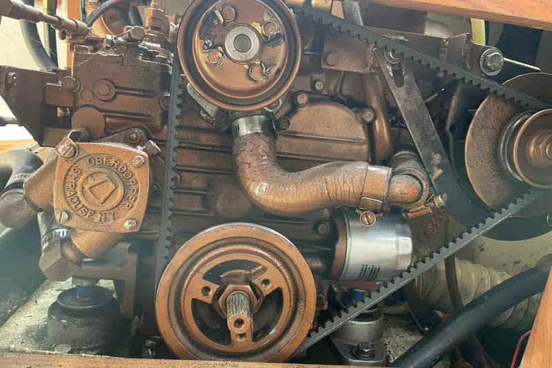 Slide: The Image of Engine of a 1989 Catalina 30 sailboat, featuring belts and pulleys. - 21