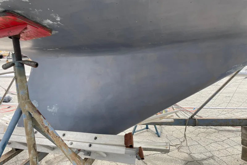 Slide: The Image of 1989 Catalina 30 sailboat hull on a stand, undergoing maintenance. - 4