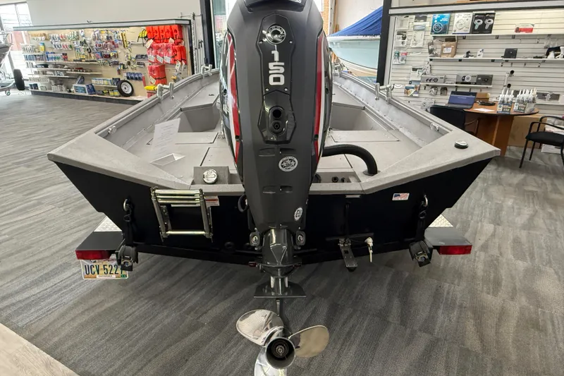 Slide: The Image of 2020 Alumacraft 20 Bay boat with 150 HP engine displayed in a showroom. - 20