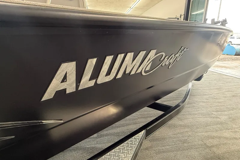 Slide: The Image of 2020 Alumacraft 20 Bay boat, close-up of logo on sleek black hull. - 22