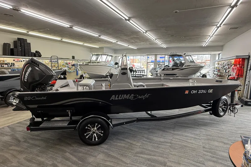 Slide: The Image of 2020 Alumacraft 20 Bay boat displayed in a showroom with other boats. - 23