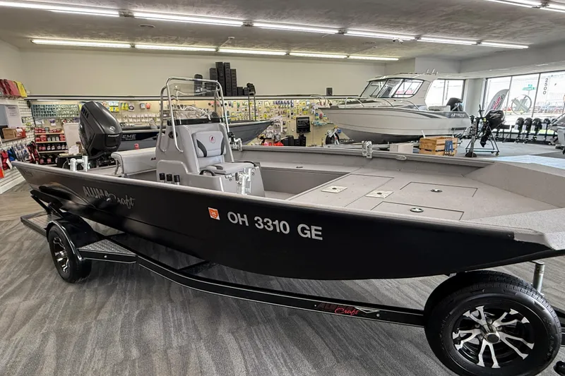 Slide: The Image of 2020 Alumacraft 20 Bay boat displayed indoors on a trailer. - 24