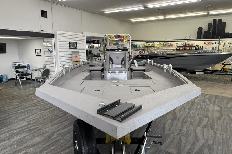 Slide: The Image of 2020 Alumacraft 20 Bay boat displayed in a showroom with fishing gear. - 26