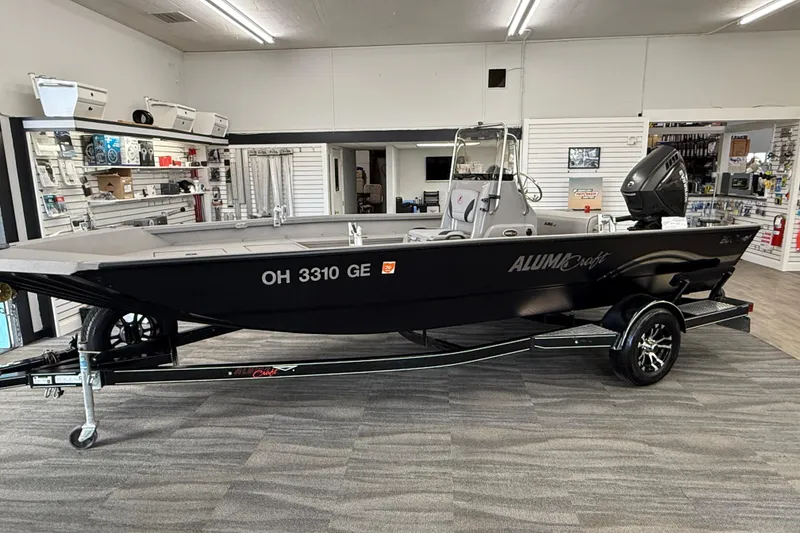 Slide: The Image of 2020 Alumacraft 20 Bay boat displayed indoors on a trailer. - 28