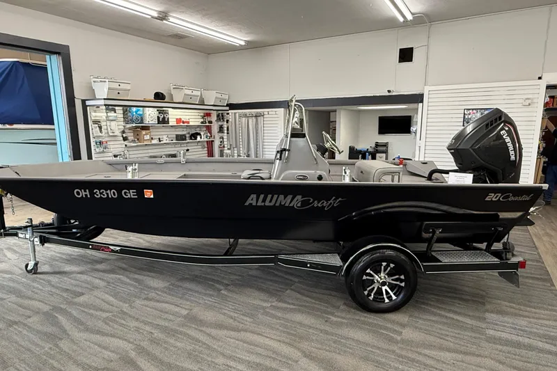 Slide: The Image of 2020 Alumacraft 20 Bay boat displayed indoors with Evinrude motor. - 29