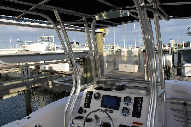 Slide: The Image of 2017 Robalo R200 Center Console boat docked at marina, showcasing helm and controls. - 11