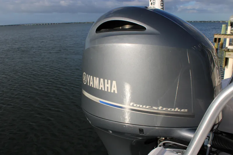 Slide: The Image of Yamaha four-stroke engine on 2017 Robalo R200 Center Console boat by the water. - 13