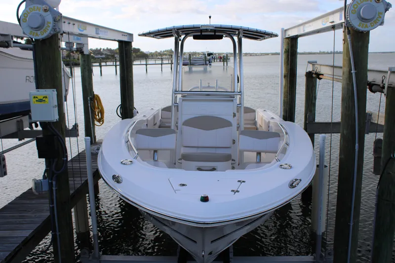 Slide: The Image of 2017 Robalo R200 Center Console boat docked on a lift by the water. - 16