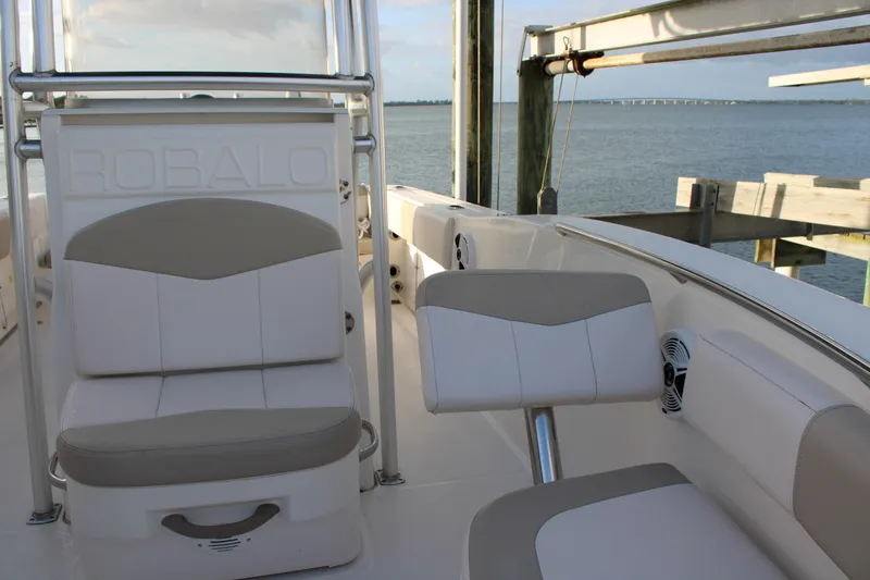 Slide: The Image of 2017 Robalo R200 Center Console boat interior with seating, docked by the water. - 23