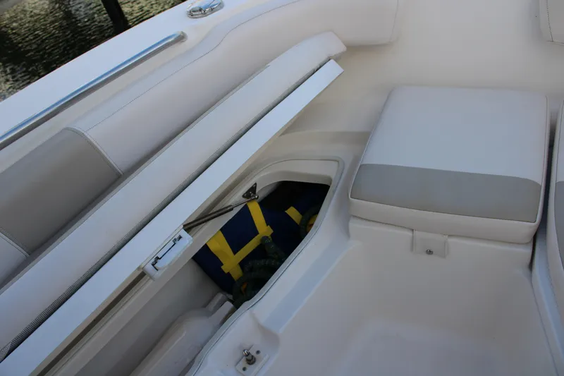 Slide: The Image of 2017 Robalo R200 Center Console boat storage compartment with cushioned seating. - 29