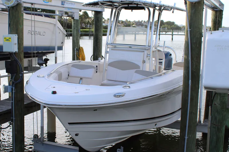 Slide: The Image of 2017 Robalo R200 Center Console boat docked on a lift by the water. - 31