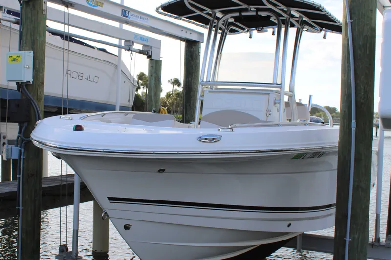 Slide: The Image of 2017 Robalo R200 Center Console boat on lift, docked near water. - 32