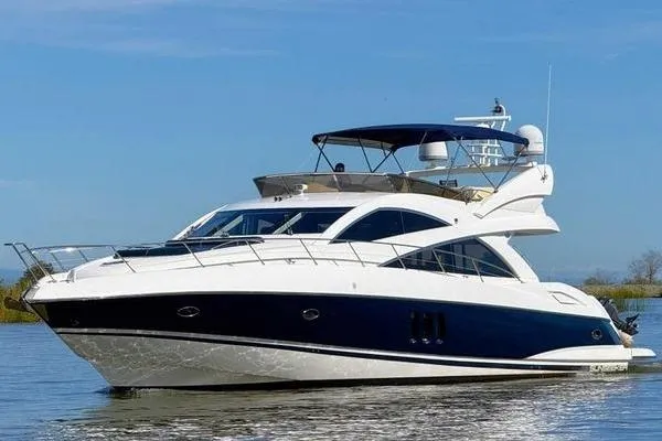 The Image of 2005 Sunseeker Manhattan 66 yacht cruising on calm waters under a clear blue sky. - 0