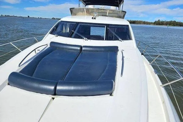 Slide: The Image of 2005 Sunseeker Manhattan 66 yacht with blue sunbed on deck, cruising on calm waters. - 20