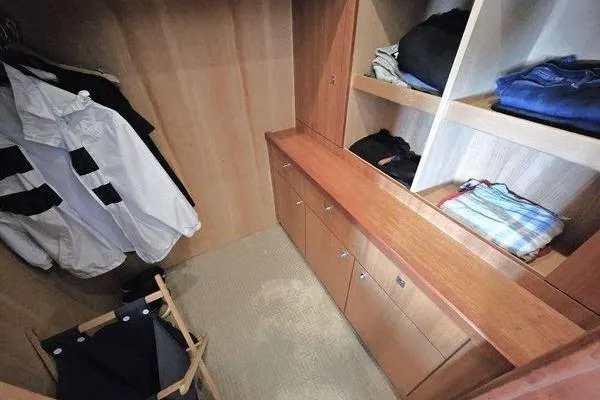 Slide: The Image of Walk-in closet on 2005 Sunseeker Manhattan 66 yacht with wooden shelves and hanging space. - 45