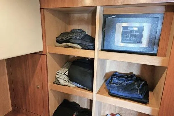 Slide: The Image of Wooden closet with clothes and a safe inside a 2005 Sunseeker Manhattan 66 yacht. - 46